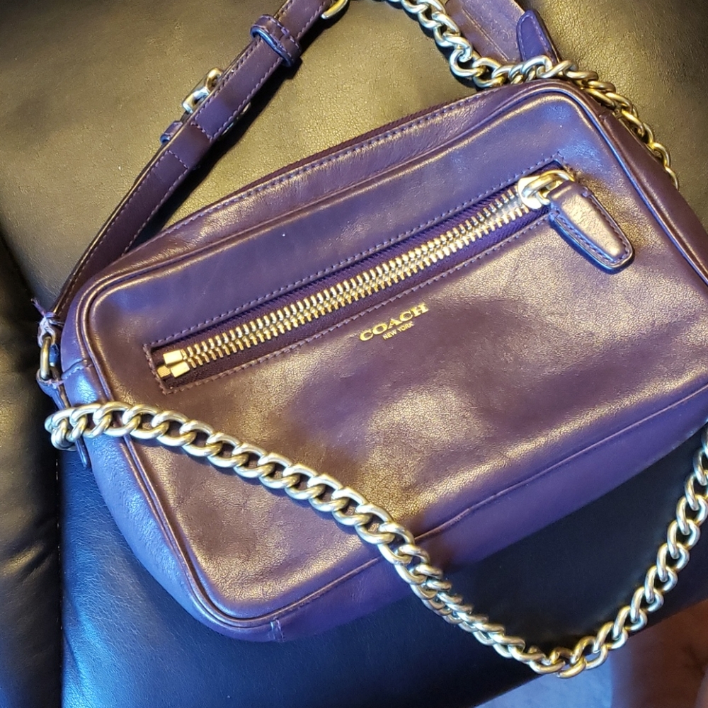 Purple Coach bag with gold strap.